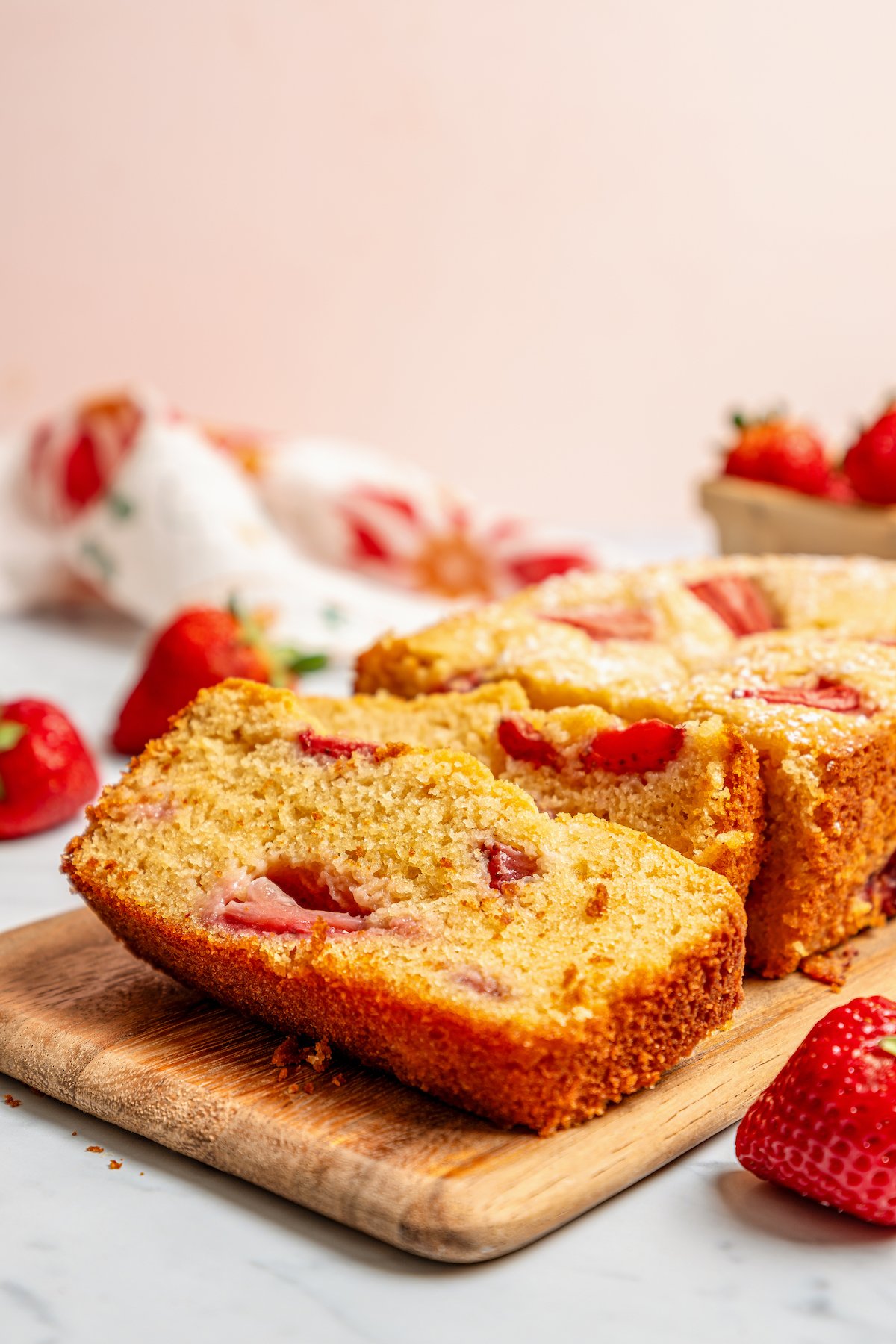 Close-up of a fluffy loaf slice with juicy strawberries in it. 